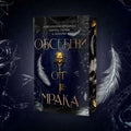 Корица на книгата „Обсебени от мрака“ с позлатен ключ и бели пера на тъмен фон